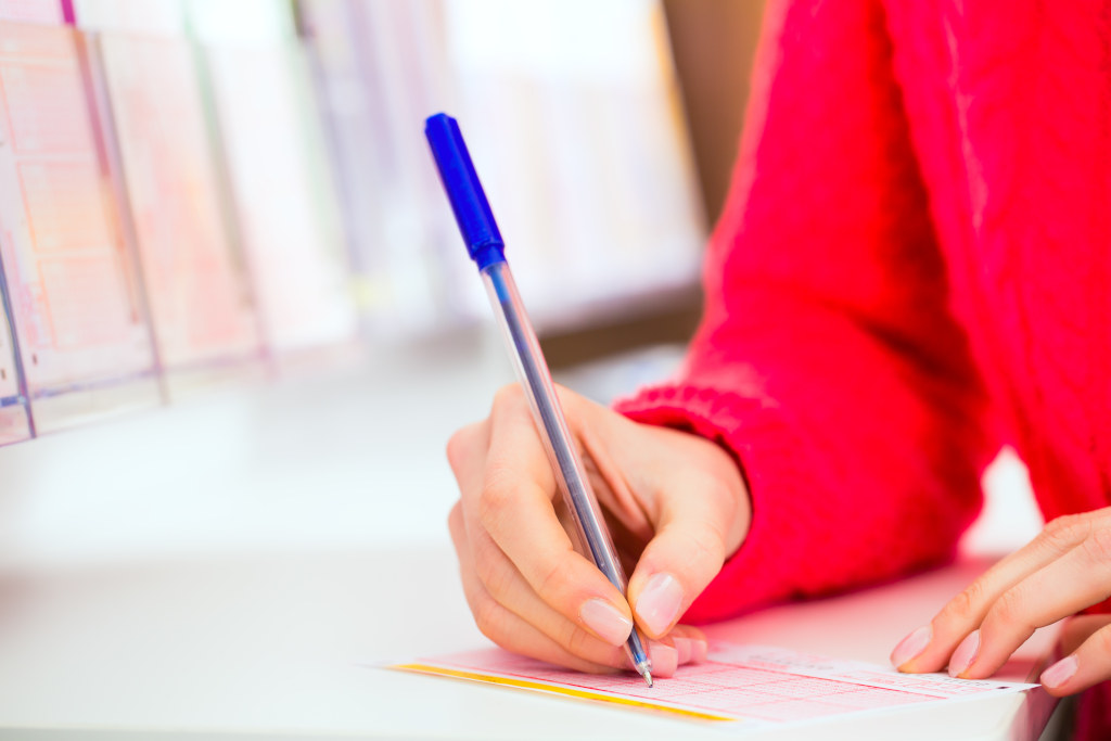 Young woman in Lotto shop playing ticket